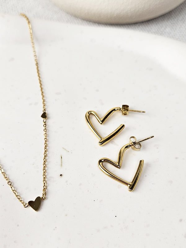 Pendientes de acero inoxidable con forma de corazón y anillos dorados.